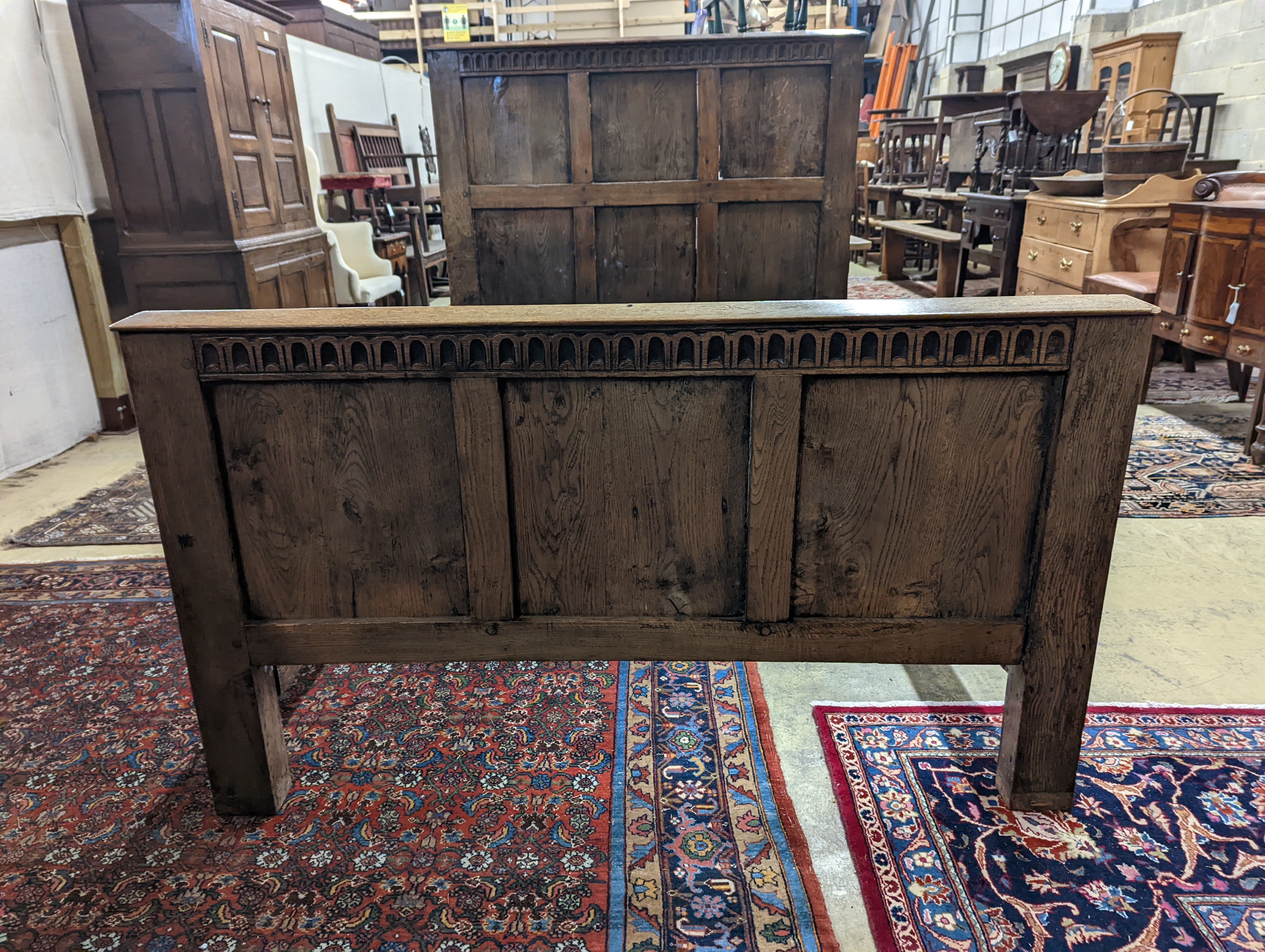 A 17th century style panelled oak bedstead, width 143cm, length 204cm, height 140cm